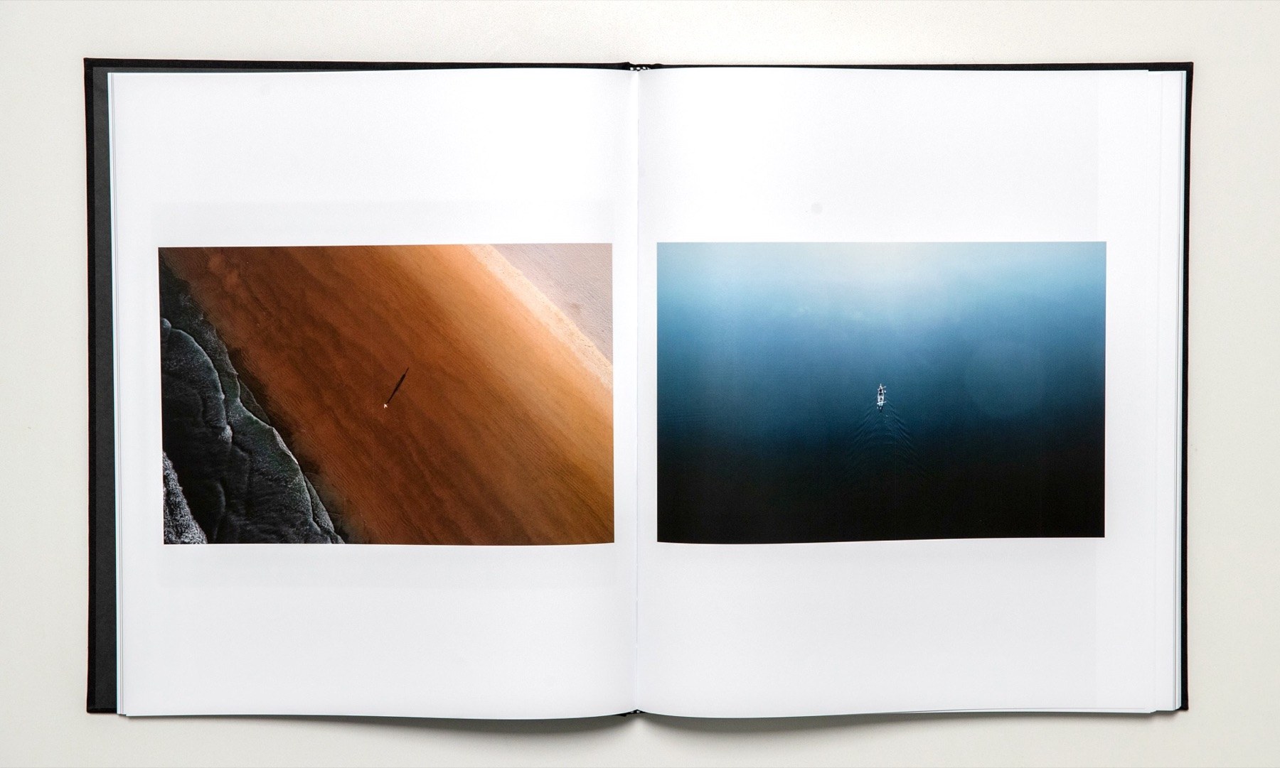Open spread with two small photographs, one of polished wood and one of deep blue water
